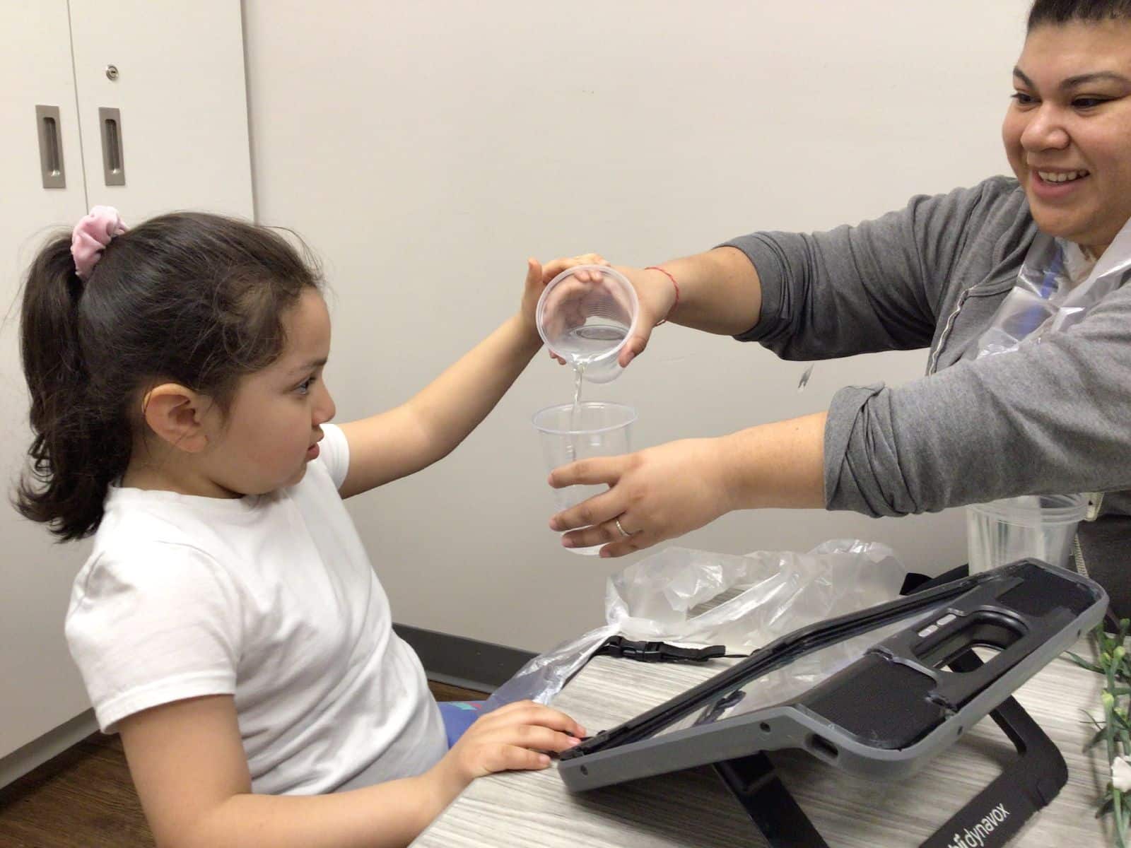 Child and therapist working on a science experiment in a therapeutic classroom