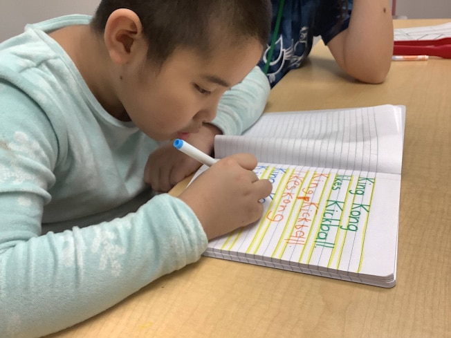 child practicing handwriting at merlin day academy