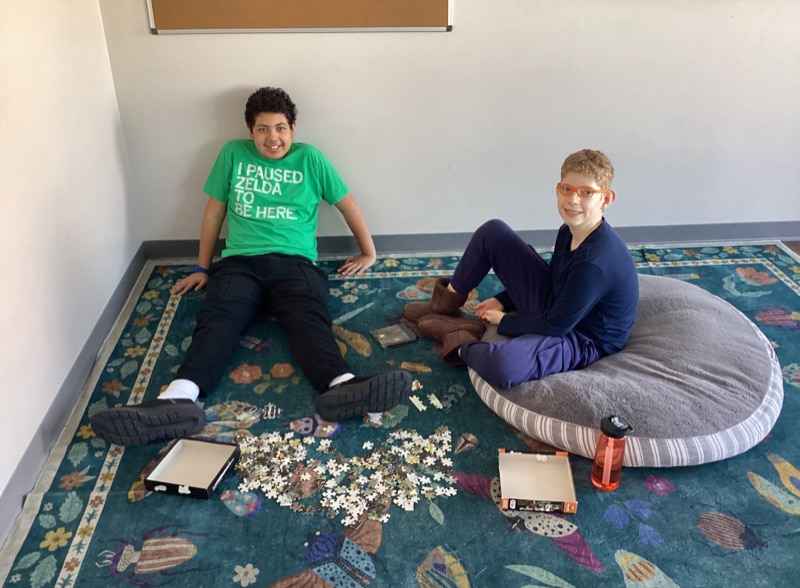 Two Merlin Day Academy students completing a puzzle together