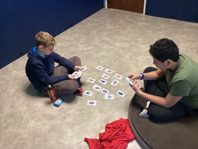 Two Merlin Day Academy students playing a card game