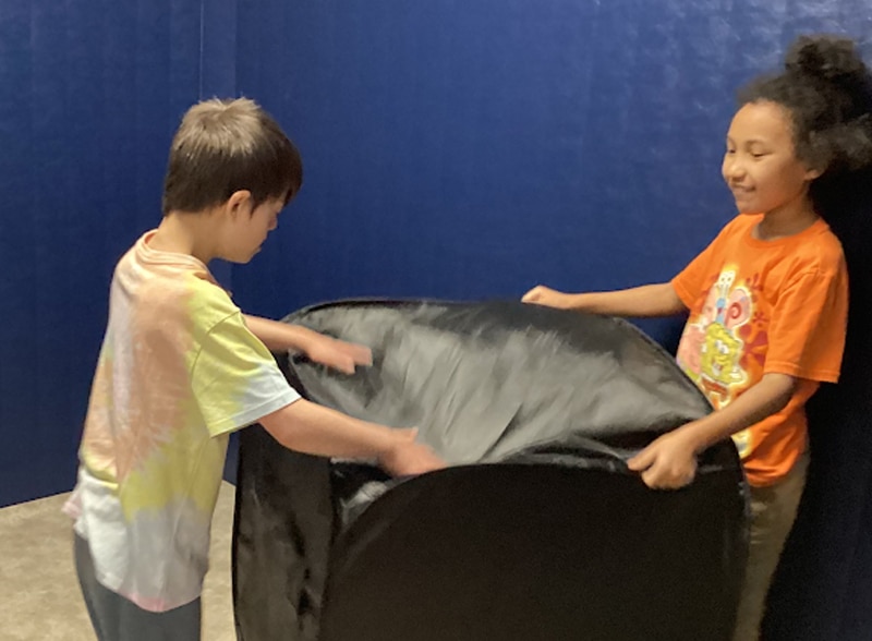 Two Merlin Day Academy students playing together in the gym