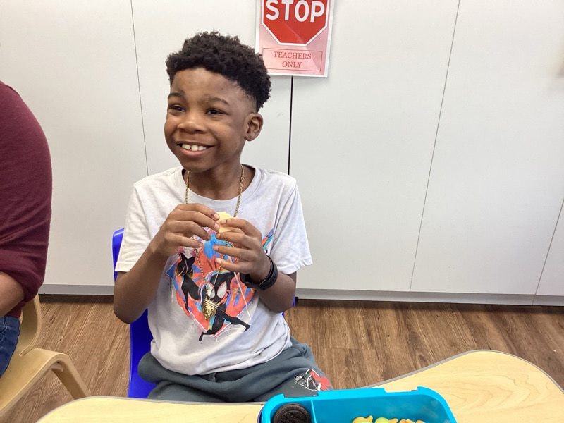 child eating snack at Merlin Day Academy