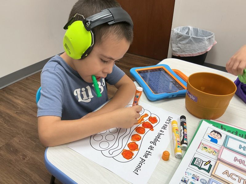 child writing worksheet at Merlin Day Academy